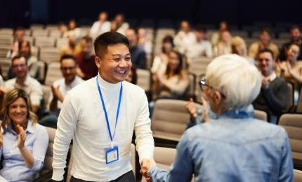 two people shaking hands at a conference event